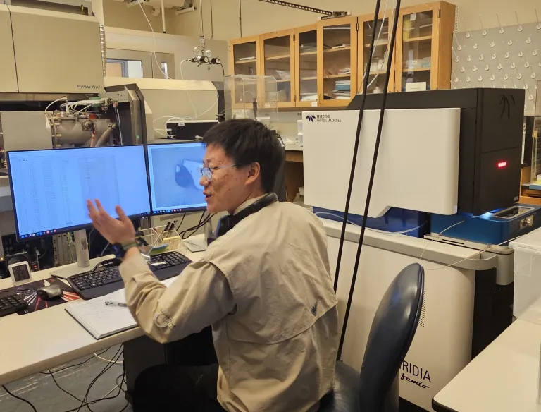 Graduate student Xuanyu Liu demonstrates the femtosecond laser system in the isotope cosmochemistry lab.
