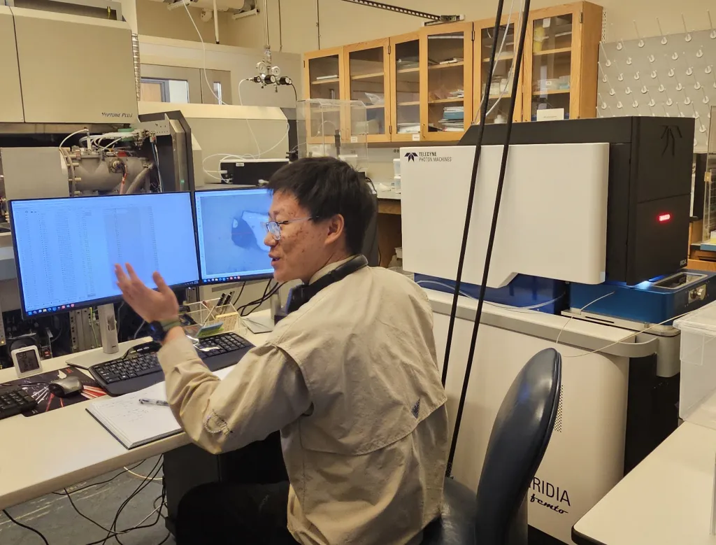 Graduate student Xuanyu Liu demonstrates the femtosecond laser system in the isotope cosmochemistry lab.